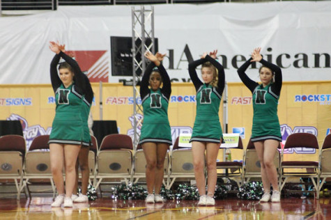 The North High cheerleaders  do the jazz hands while North shoots a free throw.