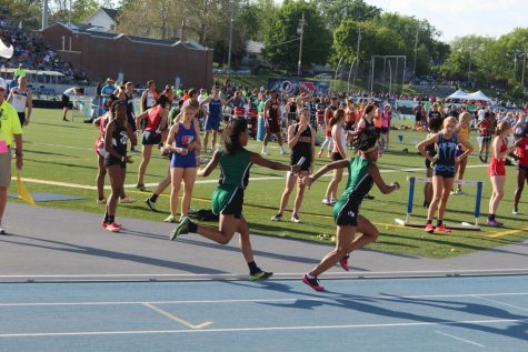 The first two runners of the girls 4x100 trade the baton and continue the race. 