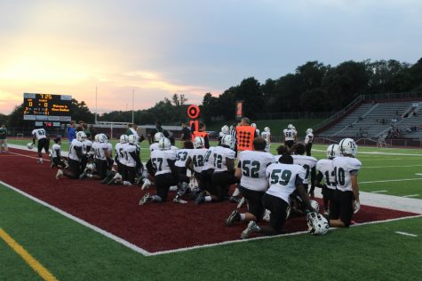 The team takes a knee for injured senior Jesse Malavong.