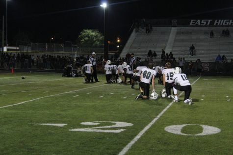 The Polar Bears take a knee for the injured player, Senior Roger Griffith.