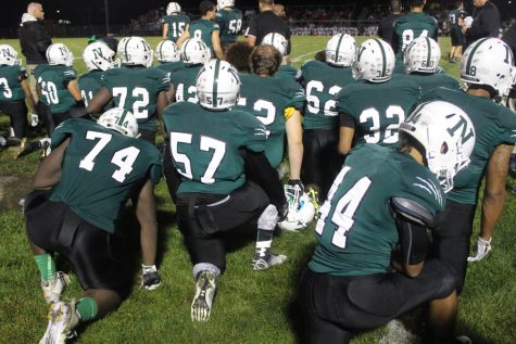 The team takes a knee for injured senior Domonique Rowland.