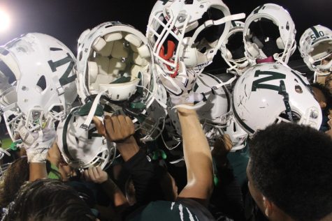 The team raises their helmets after the game.
